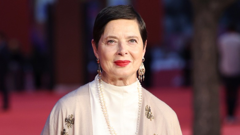 Isabella Rossellini slightly smiling while wearing red lipstick on a 2023 red carpet