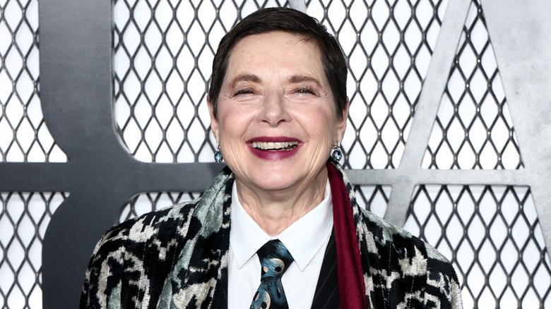 Isabella Rossellini smiling on the red carpet in front of a black and white background