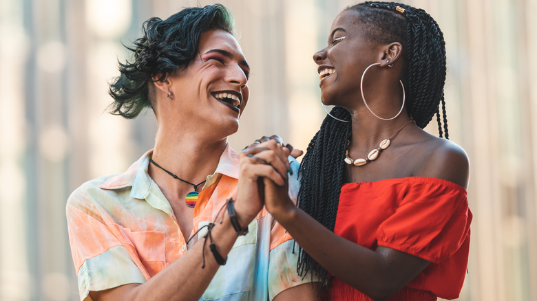 Two people hold hands laughing