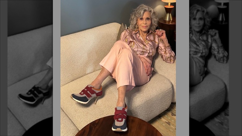 Jane Fonda smiling and posing on a sofa in 2024