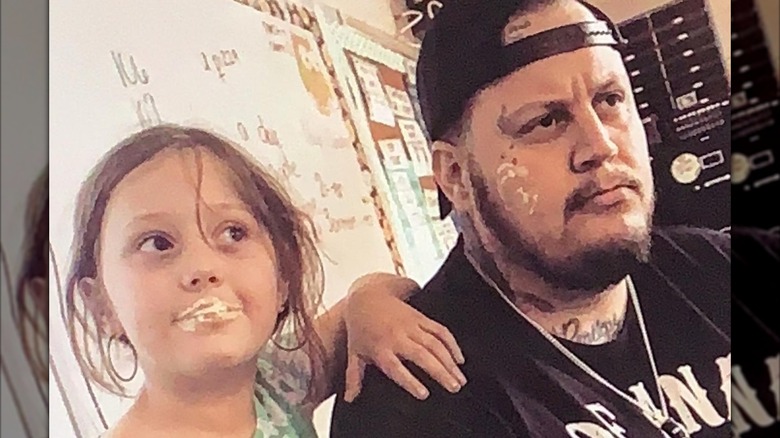 A young Bailee Ann DeFord with ice cream on her lips posing with Jelly Roll, who has a kiss mark on his cheek