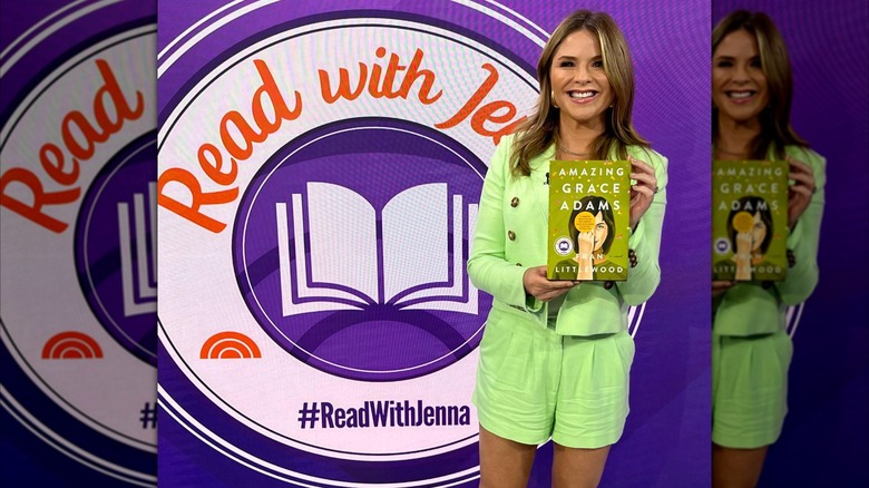 Jenna Bush Hager holding a book in front of a step and repeat