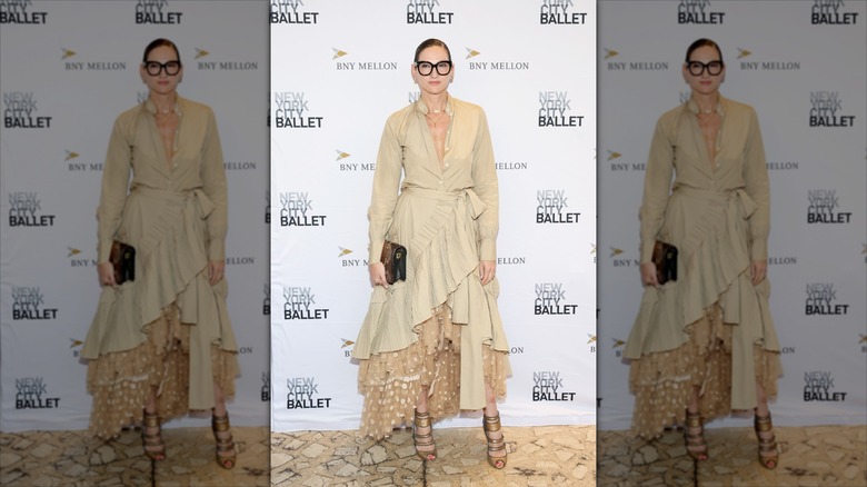 Jenna Lyons poses wearing a ruffled beige trench-style dress and a polka-dot skirt