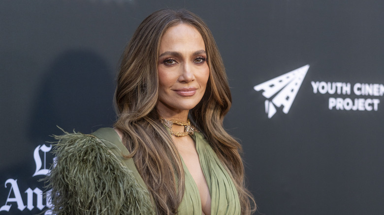 Jennifer lopez wearing a dark smoky eye and green feathered dress