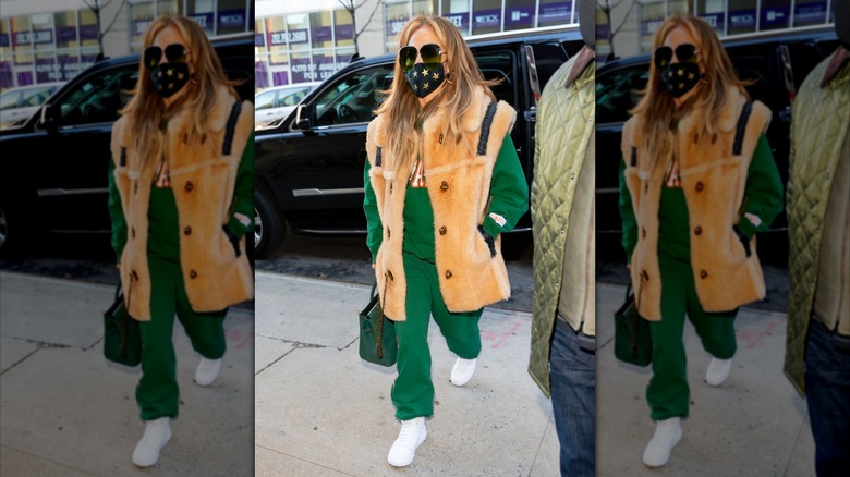 Jennifer Lopez wearing green sweats under a fur-look sleeveless jacket in 2020