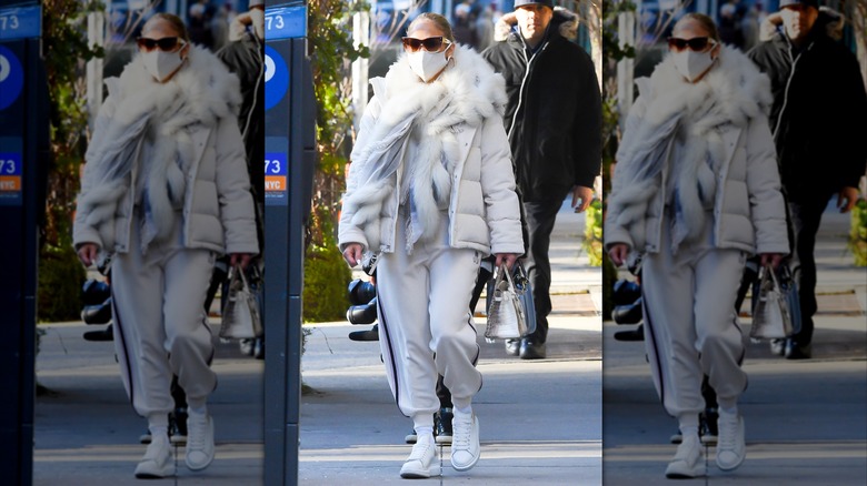 Jennifer Lopez wearing gray sweats with a bulky coat and fur-look scarf