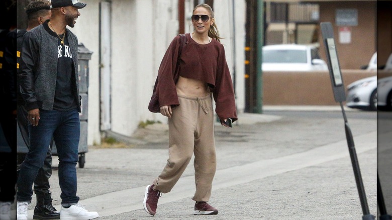 Jennifer Lopez wearing a two-tone brown sweats look and sunglasses in 2024