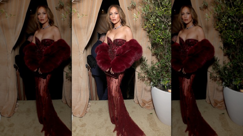 Jennifer Lopez in a sparkly, wine-red gown with a matching fur coat