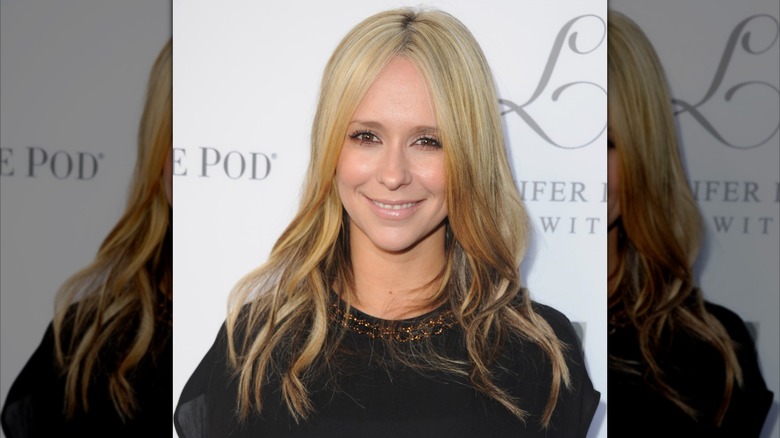Jennifer Love Hewitt smiling on the red carpet with long hair that's blond at top and brown underneath