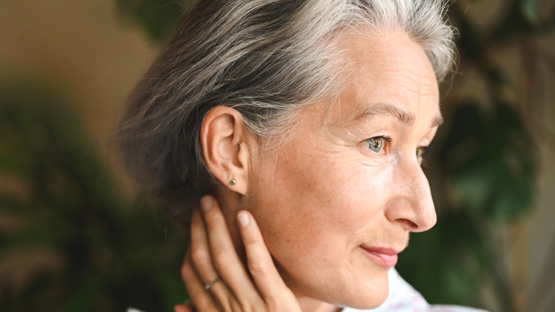 Close-up of a smiling senior woman wearing a dainty stud earring