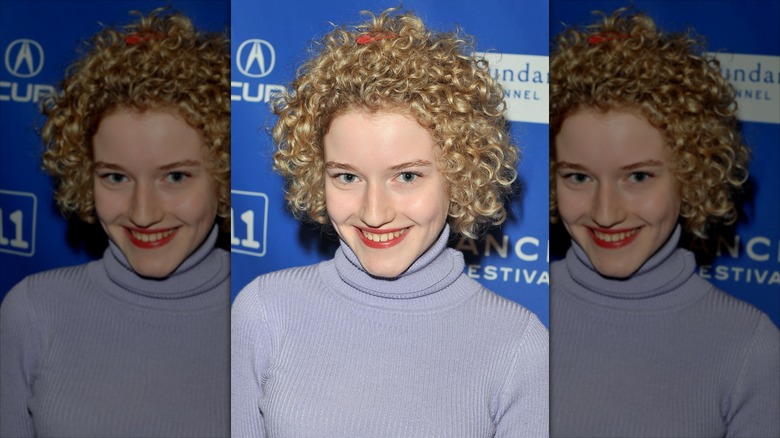 Julia Garner smiling on the red carpet in 2011