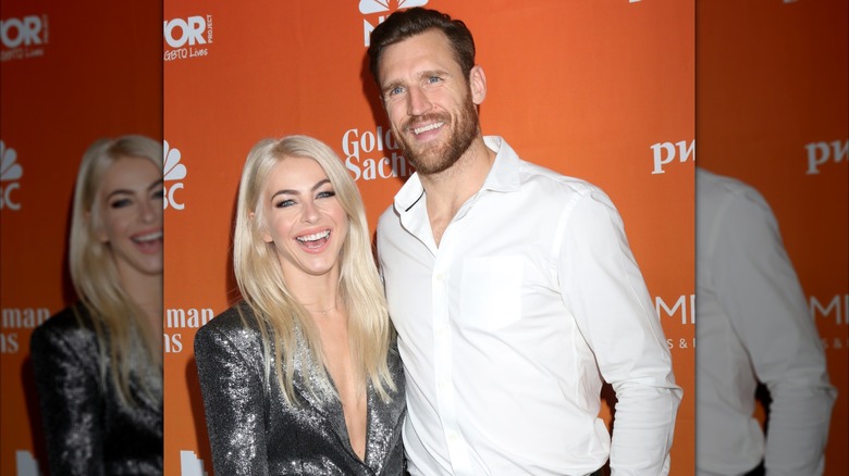 Julianne Hough wearing a silver blazer stood next to ex husband