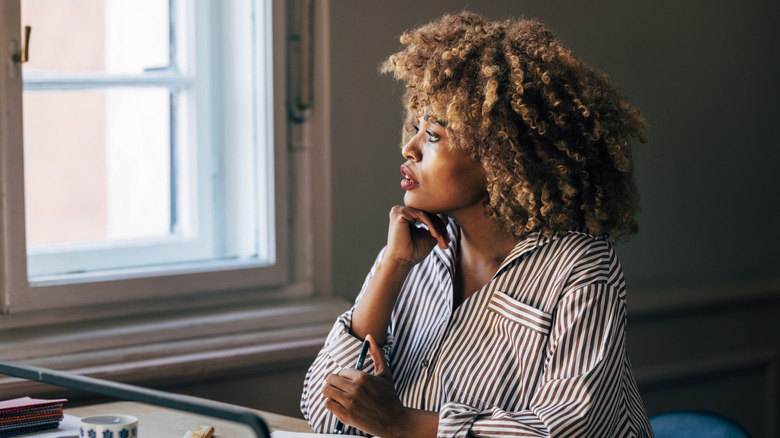 Woman gazing outside, thinking deeply