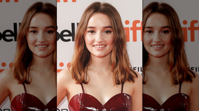 Kaitlyn Dever wearing her hair in a chest-length, middle-parted hairstyle