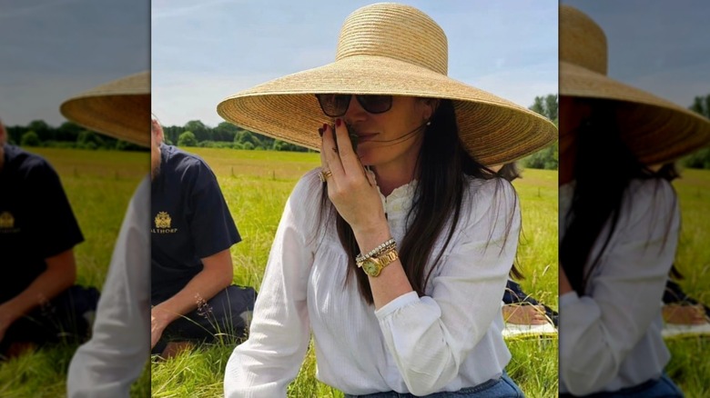 Karen Spencer in the outdoors wearing a large straw hat