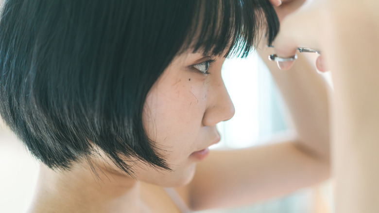 Woman trimming bangs