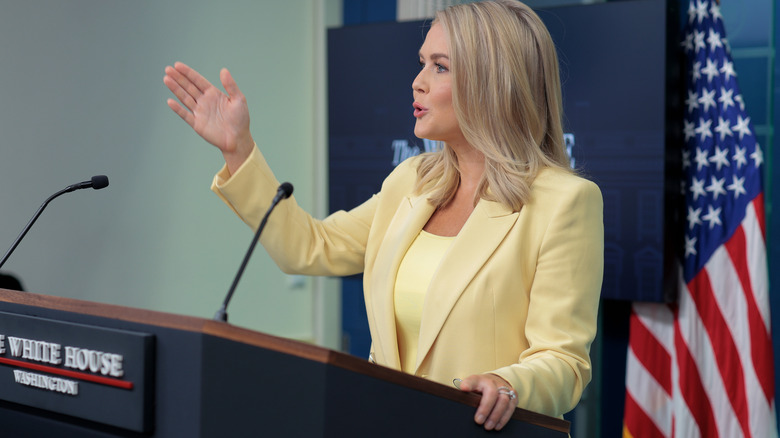 Karoline Leavitt in butter yellow at a podium