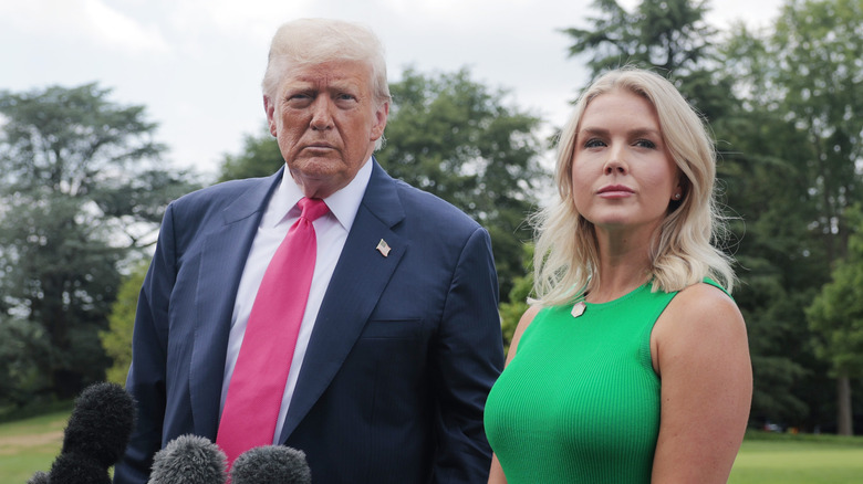Karoline Leavitt and Donald Trump outside in front of microphones