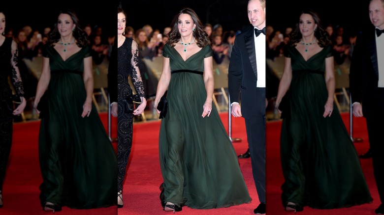 Kate Middleton on the red carpet in a dark green dress with an empire waist and cap sleeves