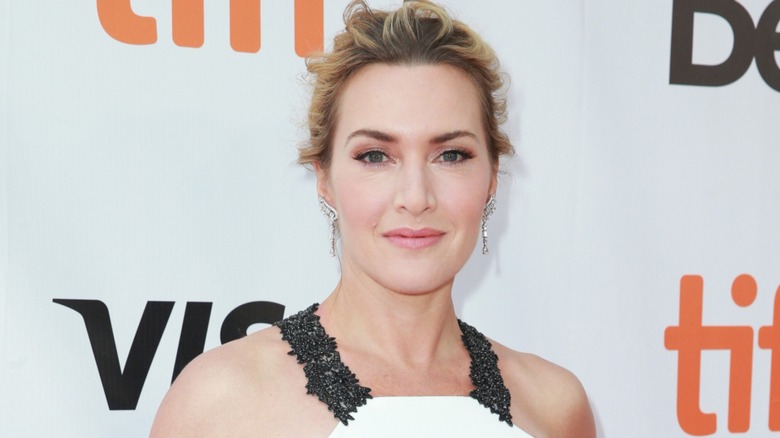 Kate Winslet posing in front of a white background on the red carpet in 2017
