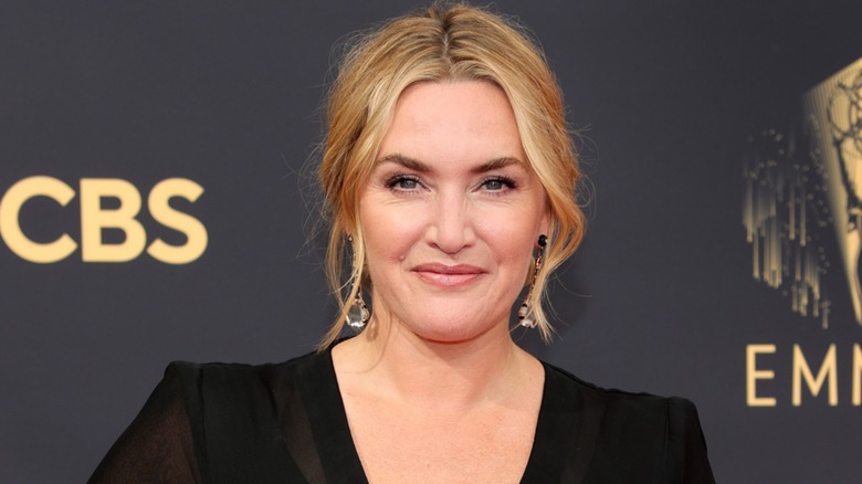Kate Winslet posing in a black dress on the Emmys red carpet in 2021