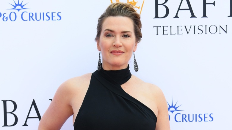 Kate Winslet with her hair pulled back in a black dress on the red carpet in 2023