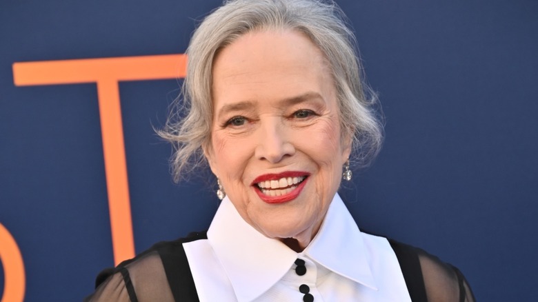 Kathy Bates wearing a red lipstick on a red carpet