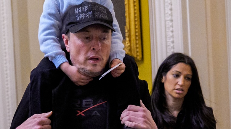 Katie Miller standing behind Elon Musk