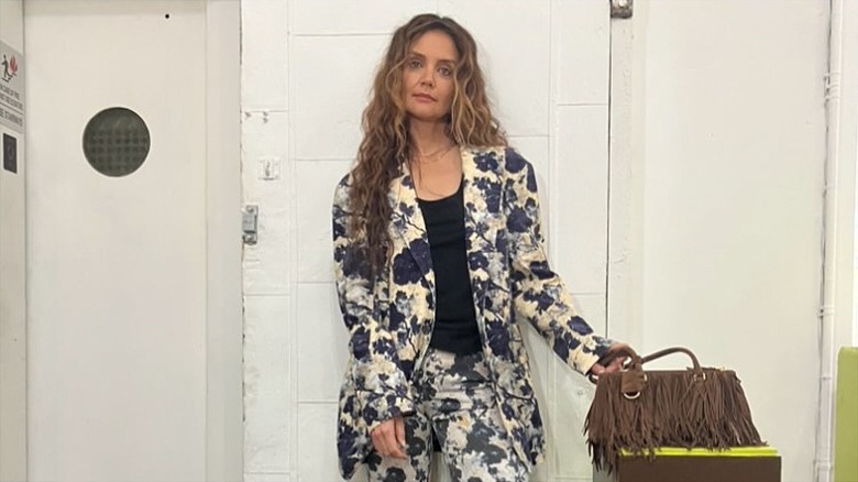 Katie Holmes on Instagram at an event with curly hair and a floral suit