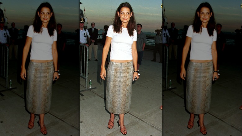 Katie Holmes on the sidewalk in a snakeskin skirt, white baby tee, and strappy sandals