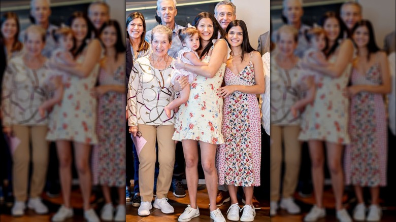 Katie Miller in a floral dress, holding her child