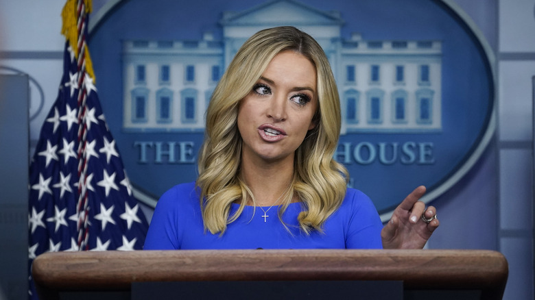 Kayleigh McEnany standing at a podium in a blue dress