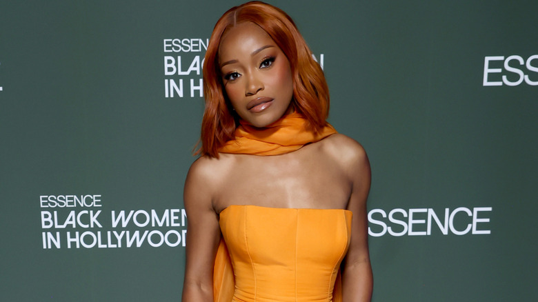 Keke Palmer in an orange strapless dress with an orange scarf