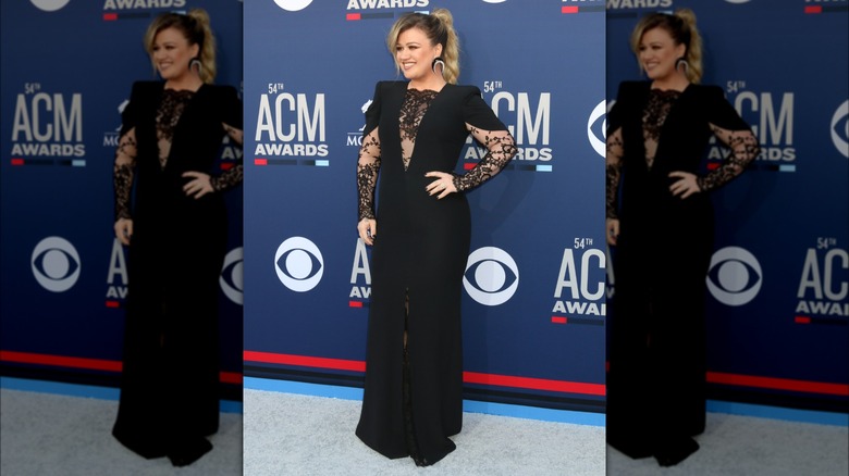 Kelly Clarkson on the red carpet in a black gown with lace details