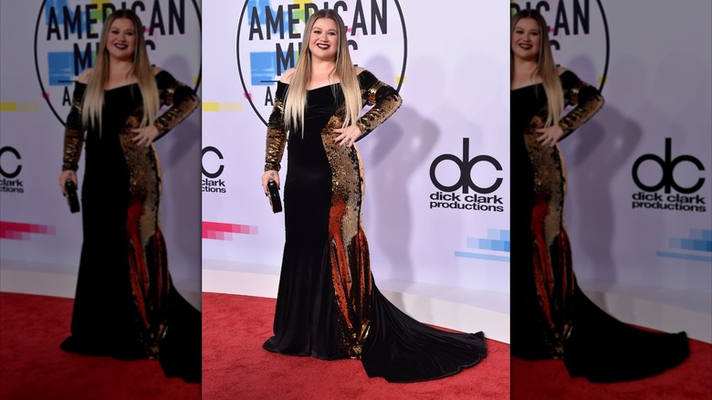 Kelly Clarkson on the red carpet in a black and gold gown