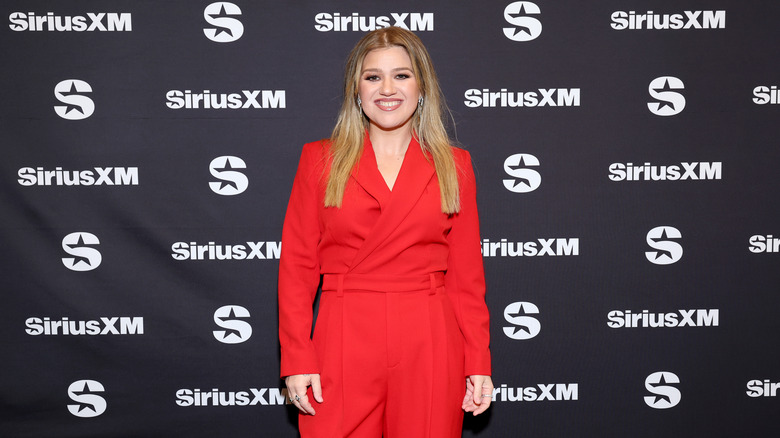 Kelly Clarkson wearing a red suit on the red carpet