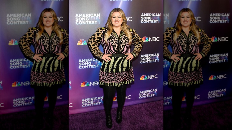 Kelly Clarkson wearing an animal print mini dress on the red carpet