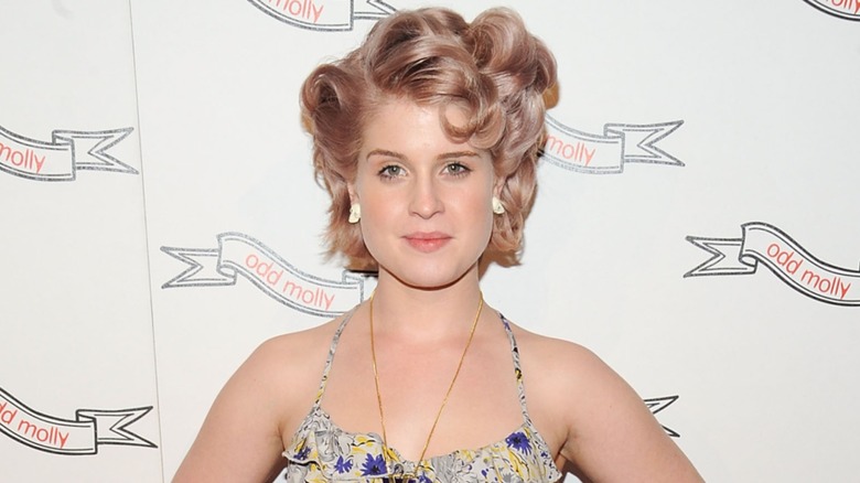 Kelly Osbourne on the red carpet in 2010 with curly light brown hair