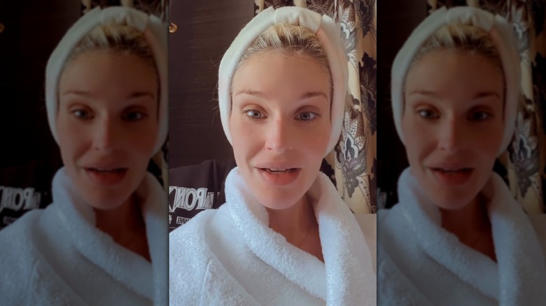 Still of Kelly Osbourne wearing a fluffy bathrobe and hair wrap while speaking to the camera