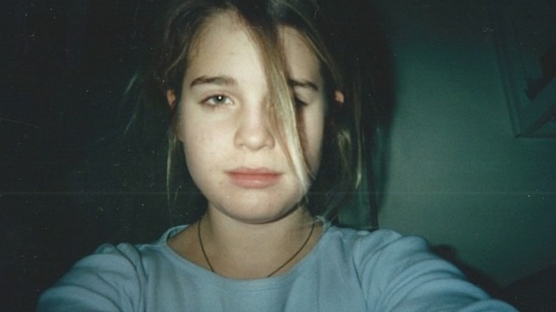 A grainy snapshot of 13-year-old Kelly Osbourne with no makeup on and piece of hair in front of one eye
