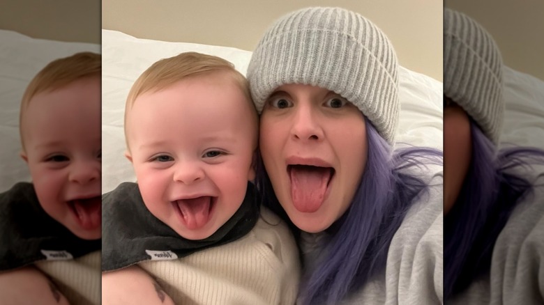Kelly Osbourne wearing a beanie and sticking her tongue out alongside her son