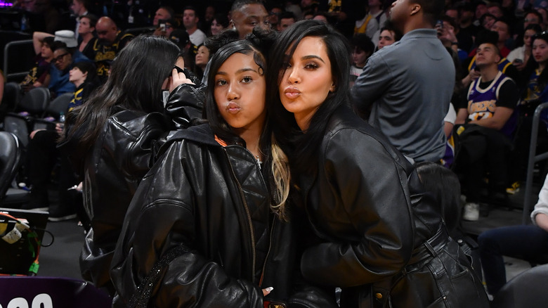 North West posing for a photo with her mom, Kim Kardashian, at a basketball game