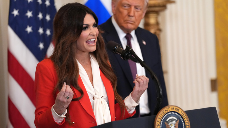 Kimberly Guilfoyle speaking at the White House while wearing a red suit