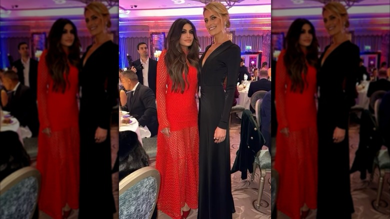 Kimberly Guilfoyle in a red dress next to a taller woman in a black dress