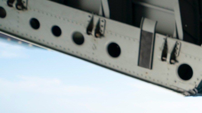 Kristi Noem seated in the open rear cargo door of a U.S. Coast Guard C-130