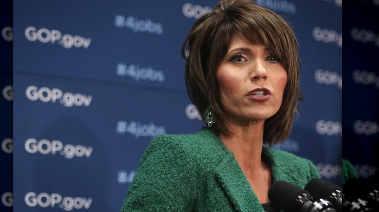 Kristi Noem gives a speech while wearing a green jacket