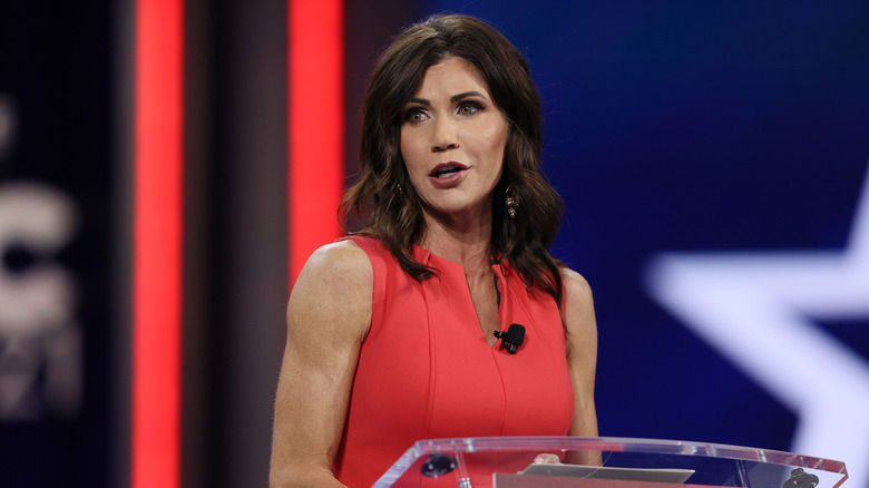 Kristi Noem speaks at a CPAC podium in 2021