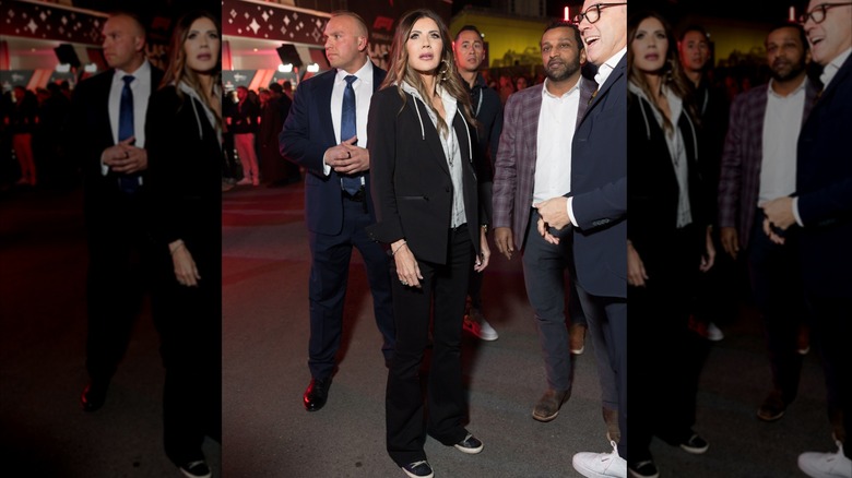 Kristi Noem, in black pantsuit over a white hoodie, at the F1 Grand Prix in Las Vegas in 2025