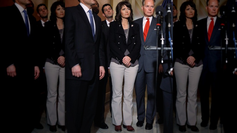 Kristi Noem, in black blazer, gray shirt, and off-white pants, alongside fellow Republicans in the U.S. Capitol in 2011