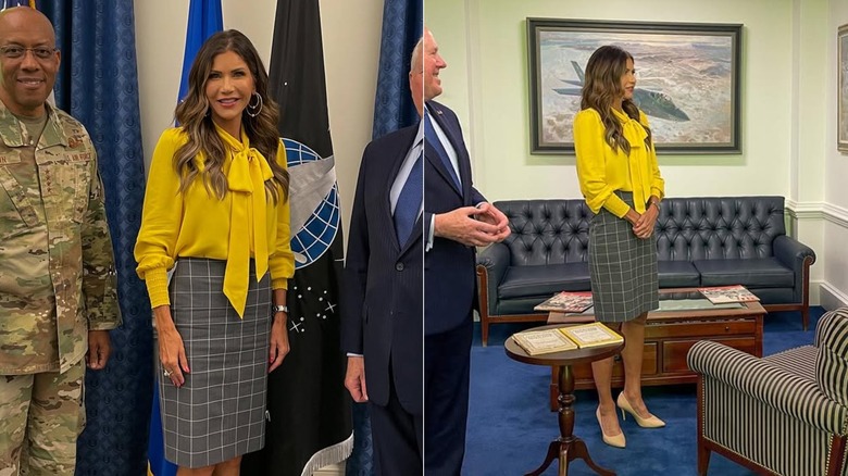 Kristi Noem in a yellow shirt looking at a framed poster in an office with an older man in a suit